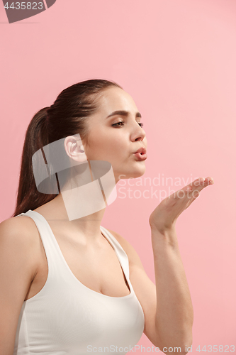 Image of Portrait of attractive cute girl with bright makeup with kiss isolated over pink background
