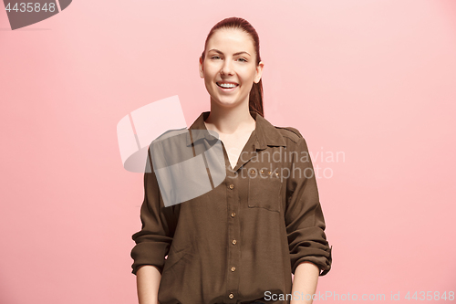 Image of The happy business woman standing and smiling against pink background.