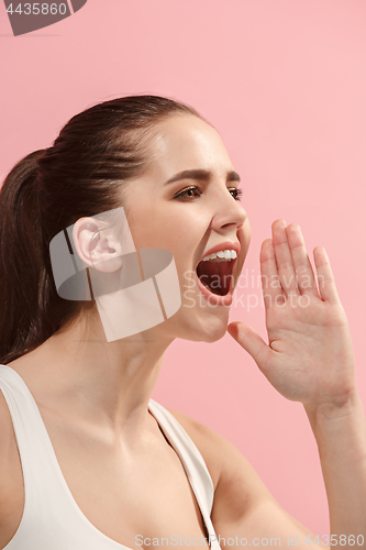 Image of Isolated on pink young casual woman shouting at studio