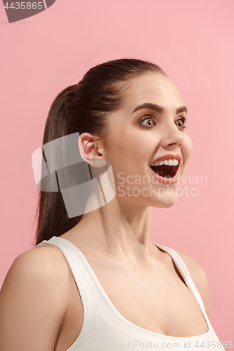 Image of The happy woman standing and smiling against pink background.