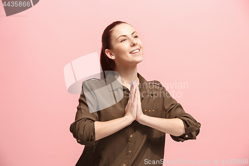Image of The happy business woman standing and smiling against pink background.