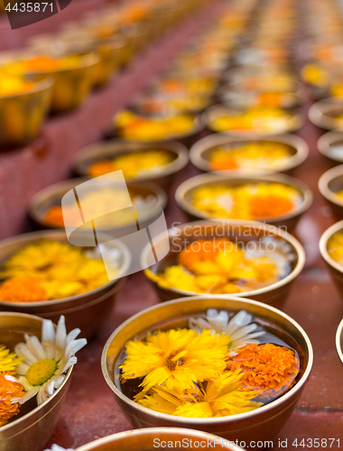 Image of Buddhist flower offerings or gifts in bowls and rows