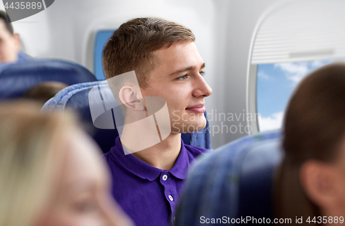 Image of happy young man travelling by plane