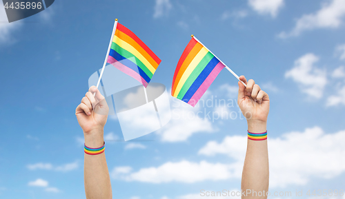 Image of hand with gay pride rainbow flags and wristbands