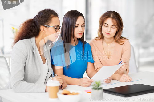 Image of businesswomen discussing papers at office