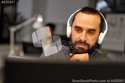 Image of creative man with headphones working at office