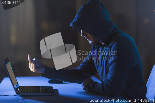 Image of hacker showing middle finger to laptop