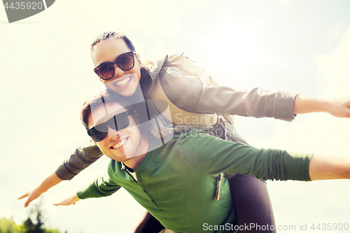 Image of happy couple with backpacks having fun outdoors