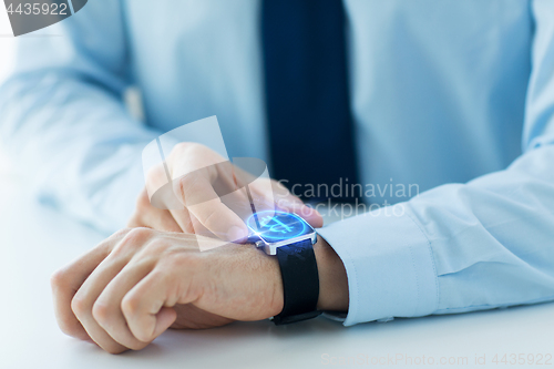 Image of close up of hands with bitcoin on smart watch