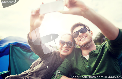 Image of couple of travelers taking selfie by smartphone