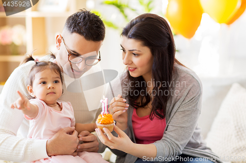 Image of baby girl with parents at home birthday party