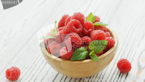 Image of Bowl with raspberries and leaves