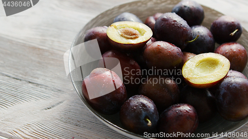 Image of Bowl of fresh plums in daylight