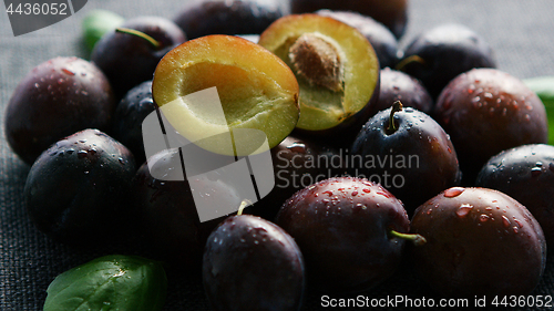 Image of Whole and sliced plumbs on table 