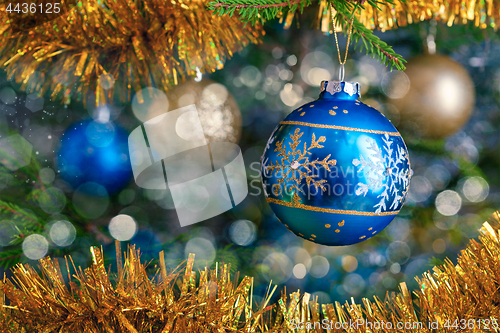 Image of Christmas-tree decoration bauble on decorated Christmas tree bac