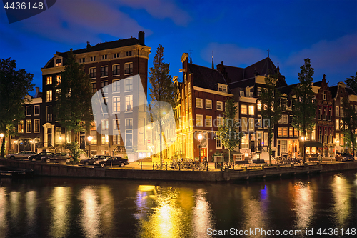 Image of Amterdam canal, bridge and medieval houses in the evening