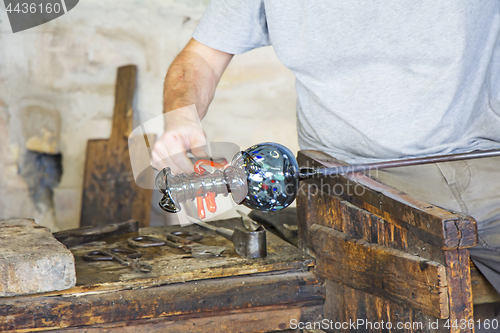 Image of Glass worker makes glass sculptures in glass factory in Murano, 