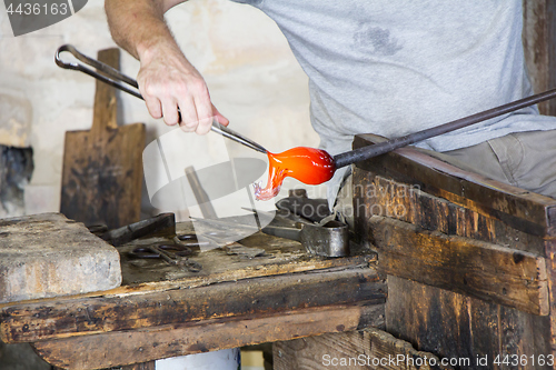 Image of Glass worker makes glass sculptures in glass factory in Murano, 