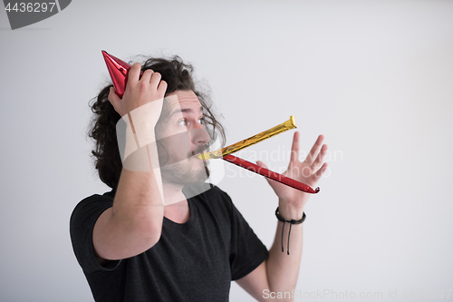 Image of Portrait of a man in party hat blowing in whistle