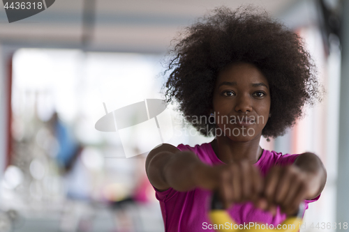 Image of woman working out in a crossfit gym with dumbbells