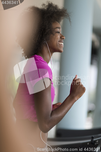 Image of afro american woman running on a treadmill