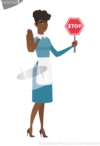 Image of African cleaner holding stop road sign.