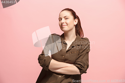 Image of The happy business woman standing and smiling against pink background.