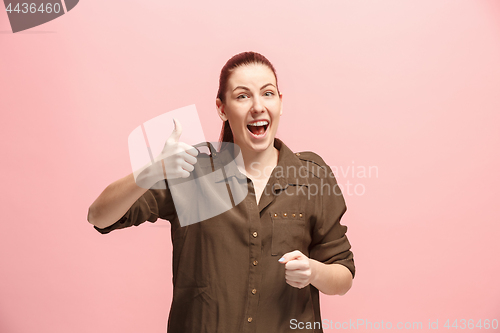 Image of The happy business woman standing and smiling against pink background.