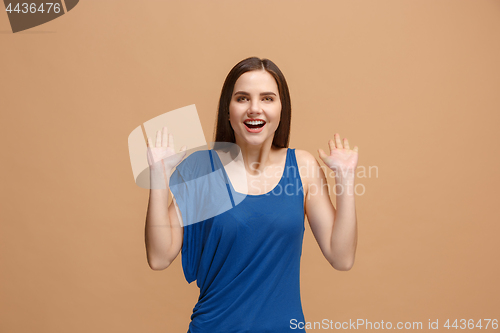 Image of The happy business woman standing and smiling against pastel background.