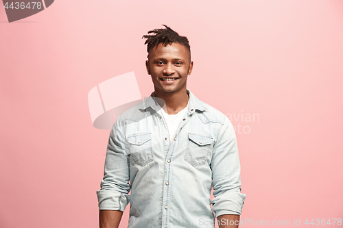 Image of The happy business man standing and smiling against pink background.