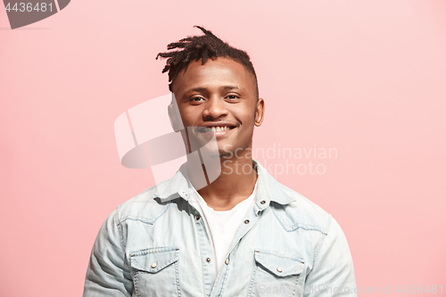 Image of The happy business man standing and smiling against pink background.