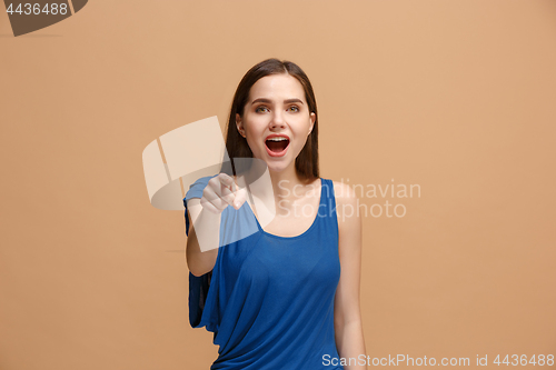 Image of The happy woman point you and want you, half length closeup portrait on pastel background.