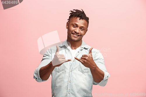 Image of The happy business man standing and smiling against pink background.