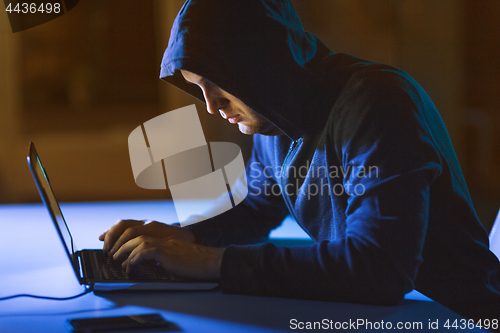 Image of hacker using laptop computer for cyber attack