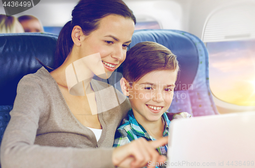 Image of happy family with tablet pc sitting in plane