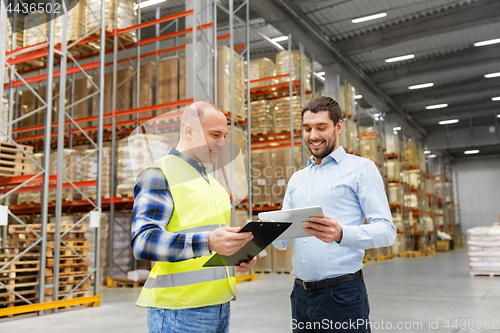 Image of worker and businessman with tablet pc at warehouse