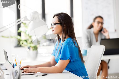 Image of businesswoman with laptop working at office