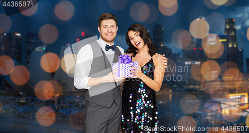 Image of happy couple with gift box at birthday party