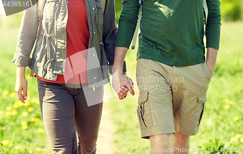 Image of close up of couple with backpacks holding hands