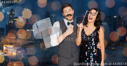 Image of happy couple with party props having fun