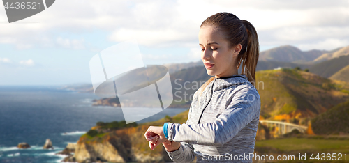 Image of woman with fitness tracker training over big sur