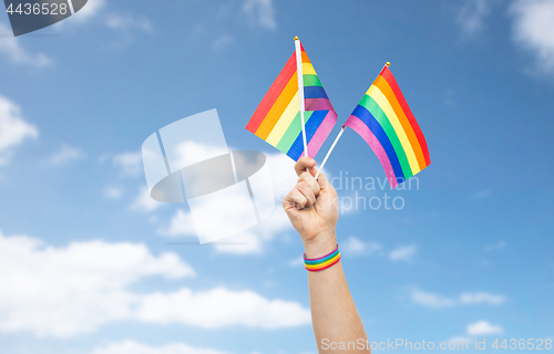 Image of hand with gay pride rainbow flags and wristband