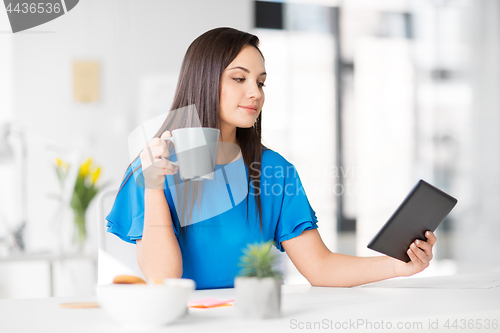Image of businesswoman with tablet pc and coffee at office