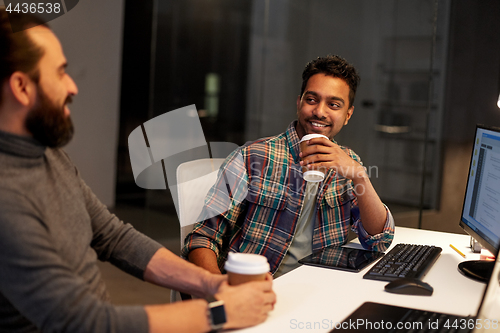 Image of creative team drinking coffee at night office