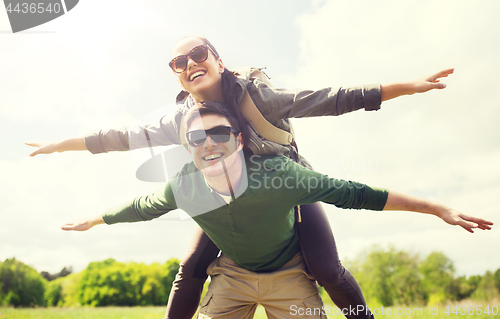Image of happy couple with backpacks having fun outdoors
