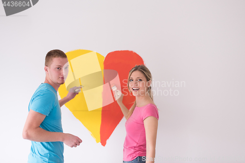 Image of couple are painting a heart on the wall