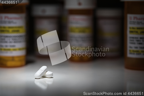 Image of Hydrocodone Pills and Prescription Bottles Under Spot Light.