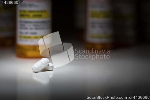 Image of Hydrocodone Pills and Prescription Bottles Under Spot Light.