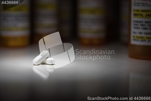 Image of Hydrocodone Pills and Prescription Bottles Under Spot Light.