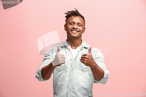 Image of The happy business man standing and smiling against pink background.